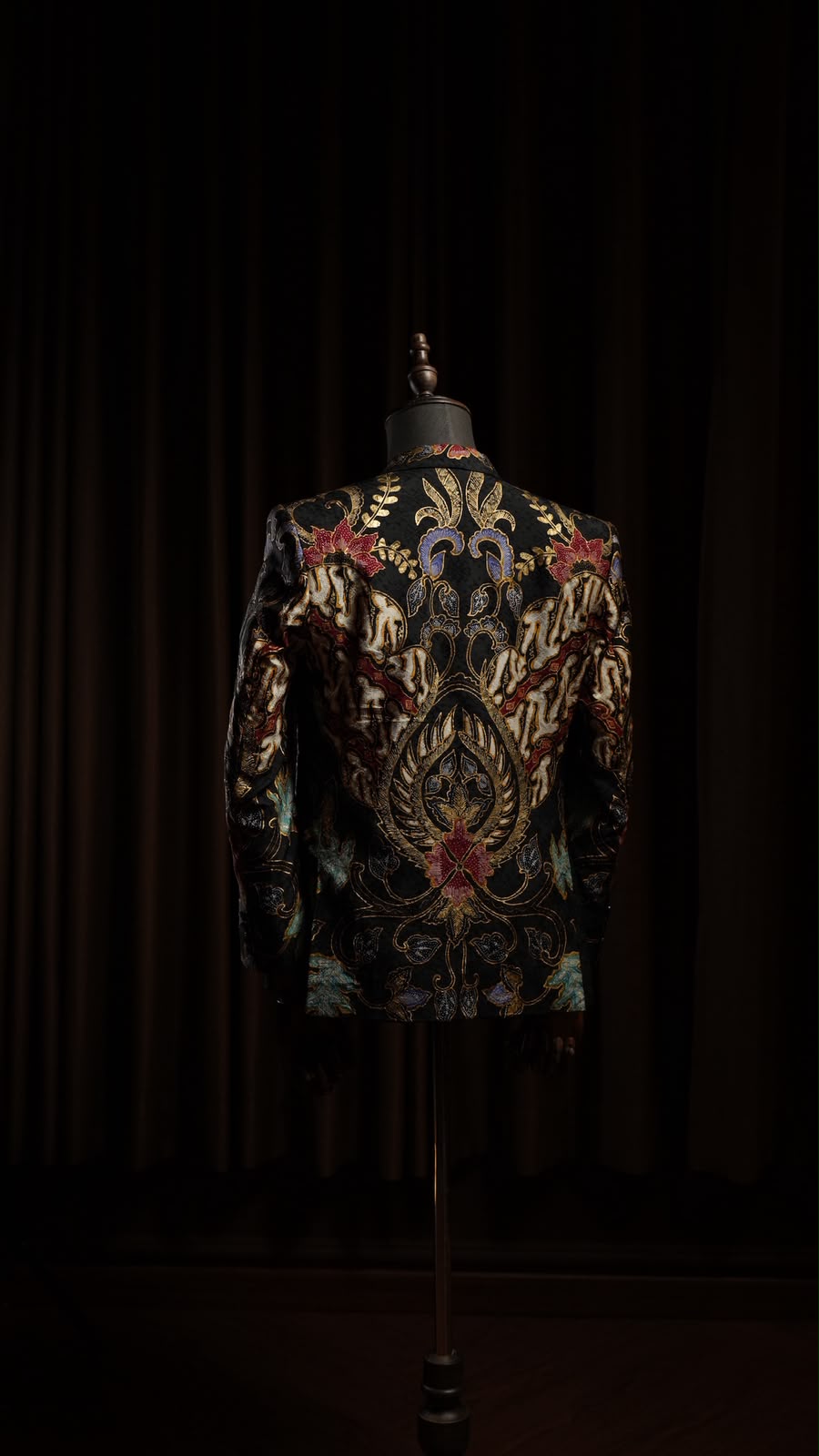 Punggung blazer batik tulis dengan medali sayap emas dan bunga sogan